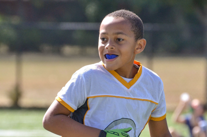 un niño practicando deporte con protector bucal.