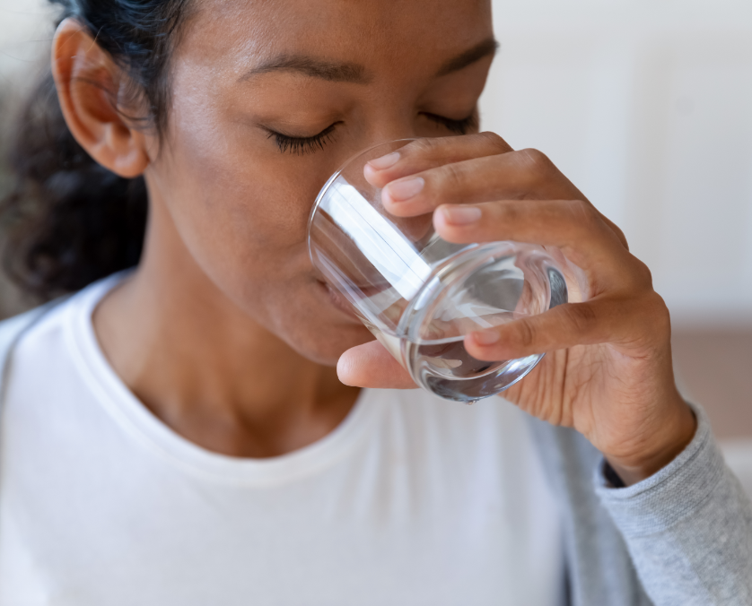 una mujer tomando un vaso de agua.